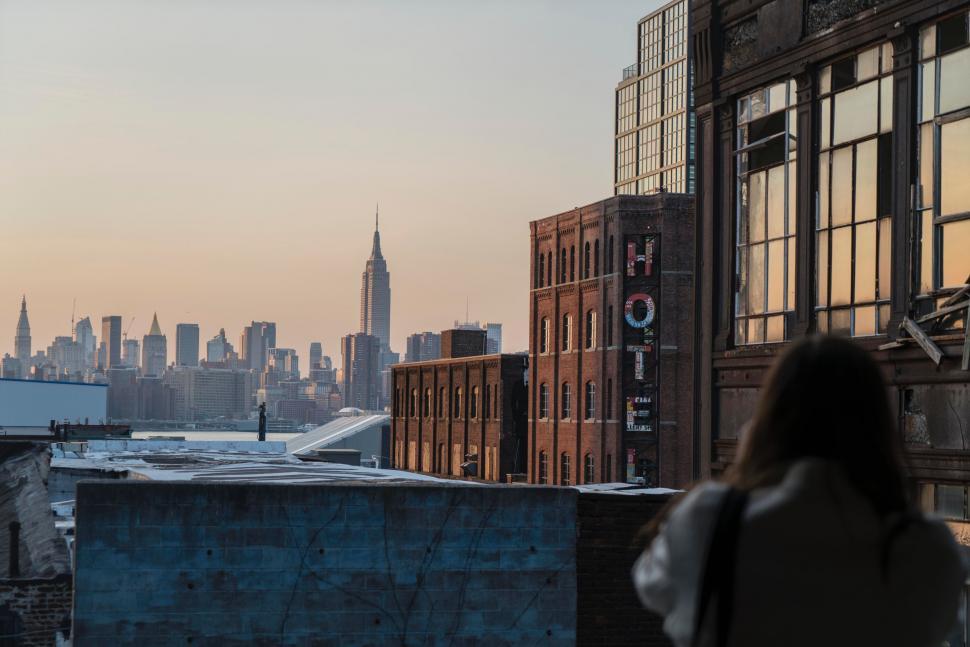 Free Image of Person Standing on Roof Looking Out at City 