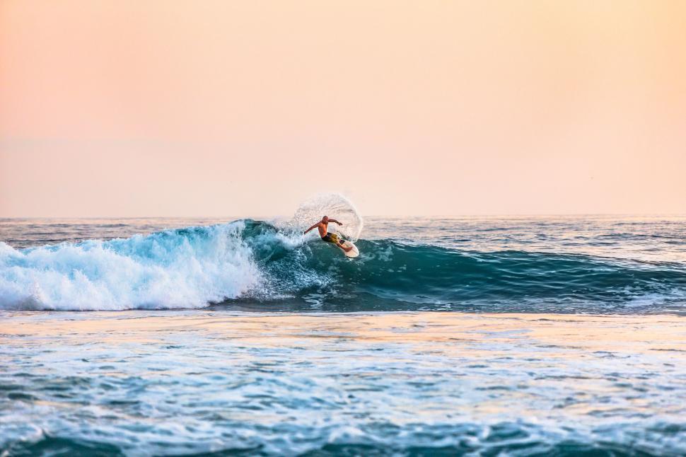 Free Image of Person Riding Wave on Surfboard 