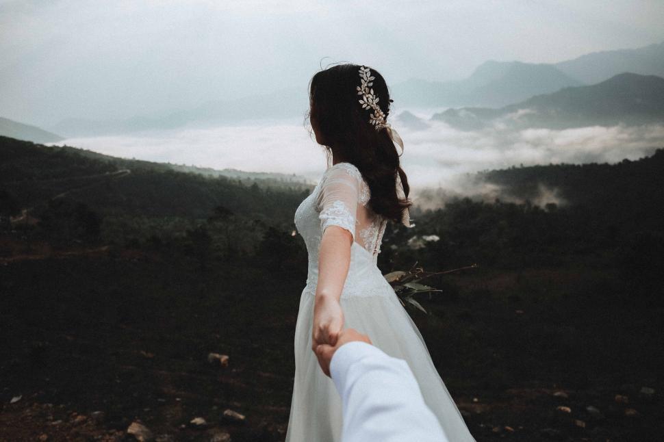 Free Image of Woman in Wedding Dress Holding Mans Hand 