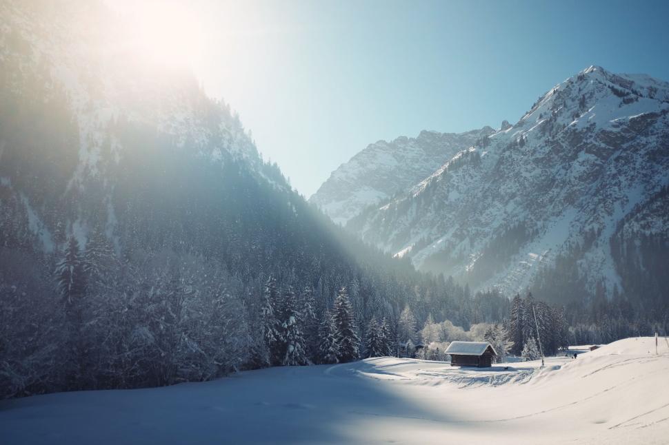 Free Image of Snow Covered Mountain With House in Foreground 