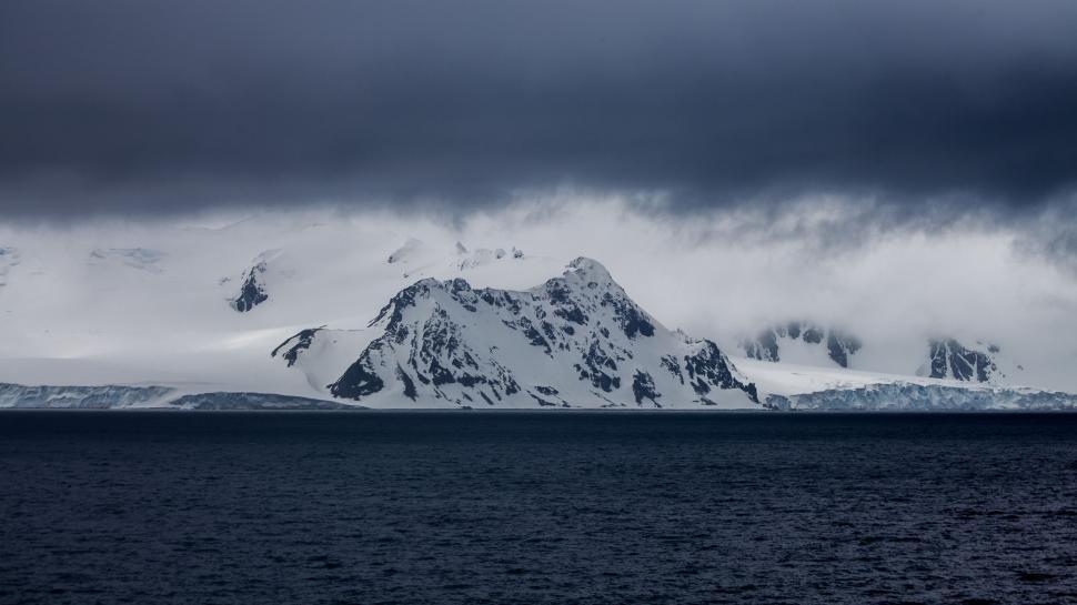 Free Image of Majestic Mountain Covered in Snow Beneath Cloudy Sky 
