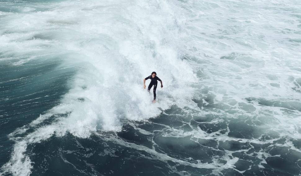 Free Image of Man Riding a Wave on Surfboard 