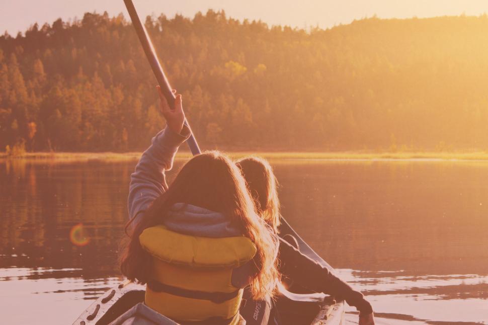 Free Image of Woman in a Yellow Life Jacket Paddling Canoe 