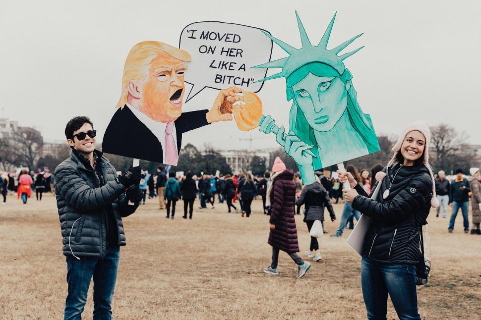 Free Image of Group of People Holding Signs in Front of Statue of Liberty 