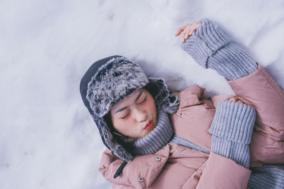 Free Image of Person Laying in Snow With Jacket and Hat 