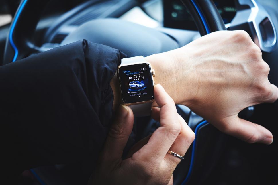 Free Image of Person Holding Smart Watch While Driving Car 