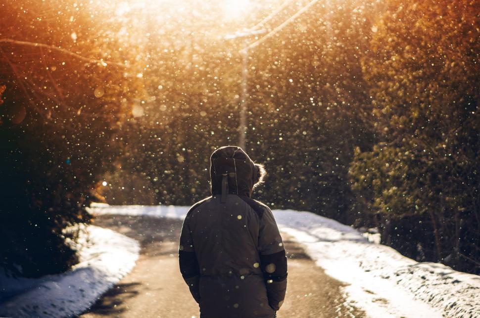 Free Image of Man Walking Down Snow Covered Road 