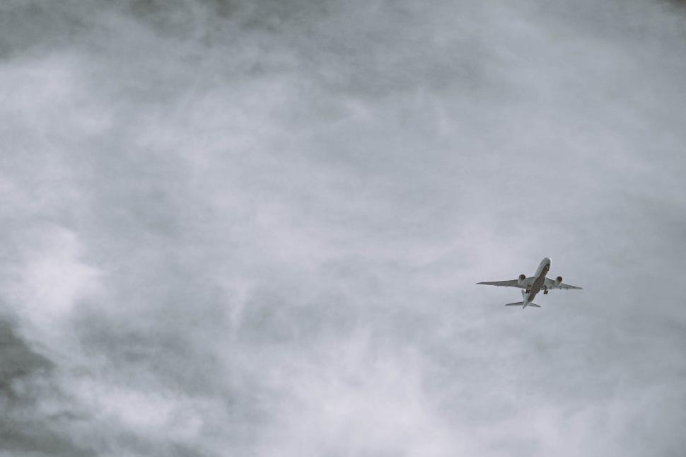 Free Image of Airplane Flying Through Cloudy Sky 