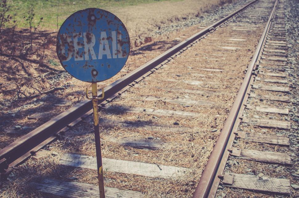 Free Image of Blue Sign Next to Train Track 