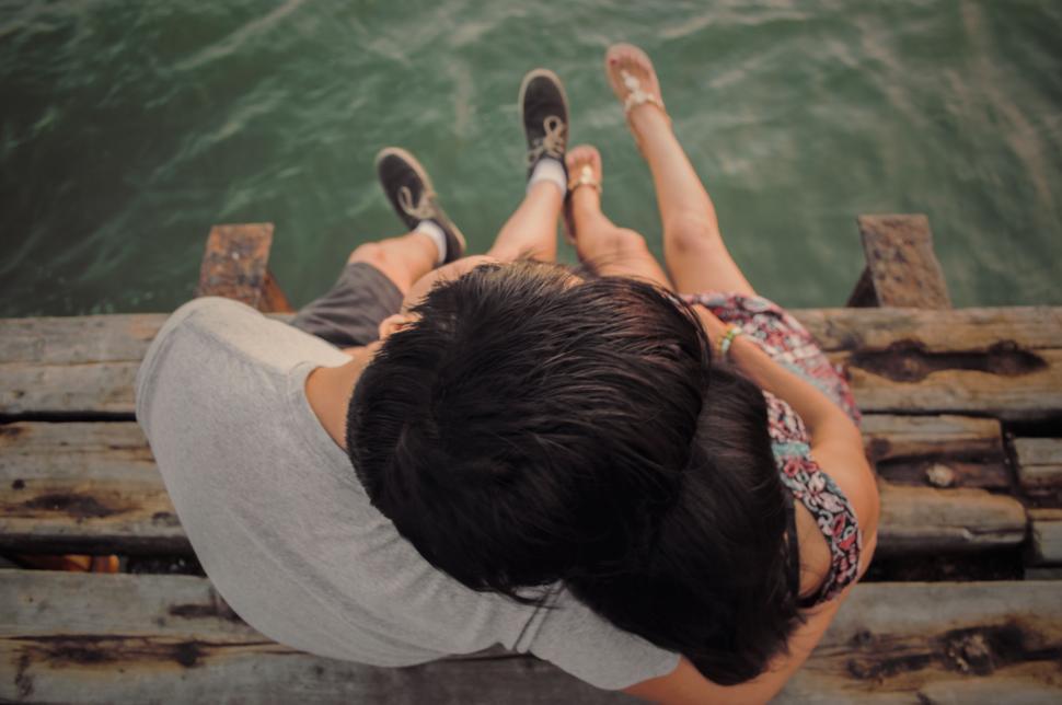 Free Image of Man and Woman Laying on Dock 