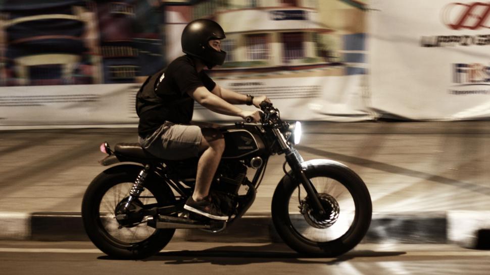 Free Image of Man Riding Motorcycle Down Urban Street 