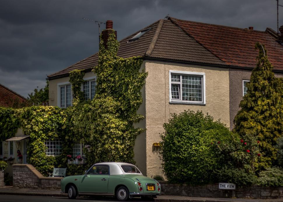 Free Image of Green Car Parked in Front of House 