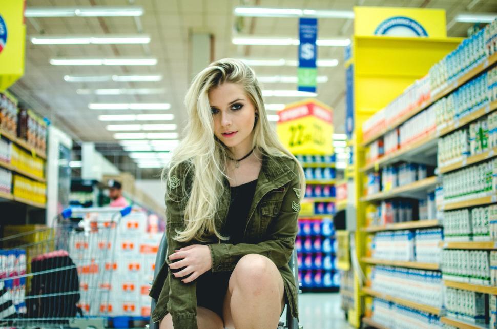 Free Image of Woman Sitting on Shopping Cart in Store 