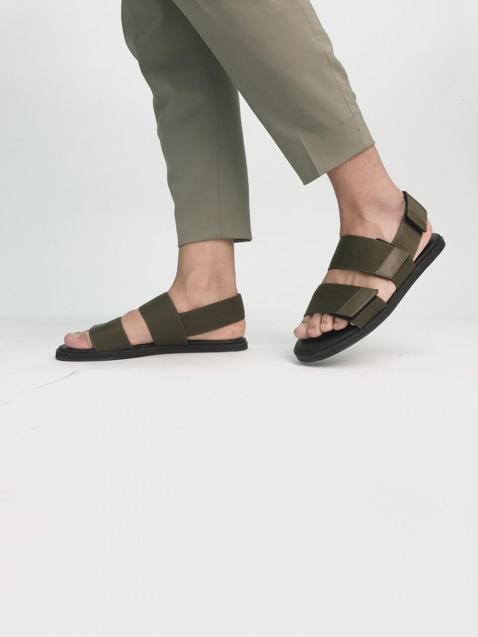 Free Image of Person Wearing Sandals Standing on White Surface 