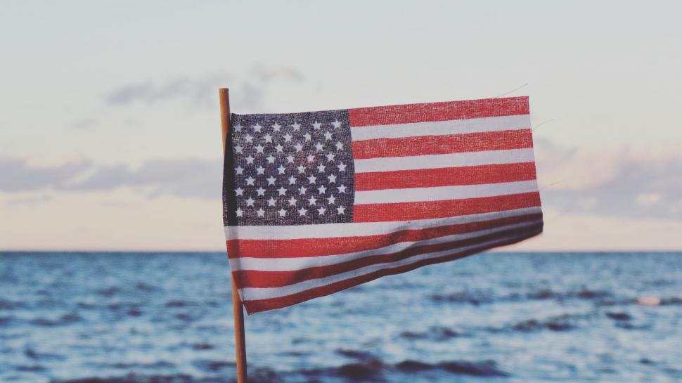 Free Image of American Flag Flying Over Body of Water 