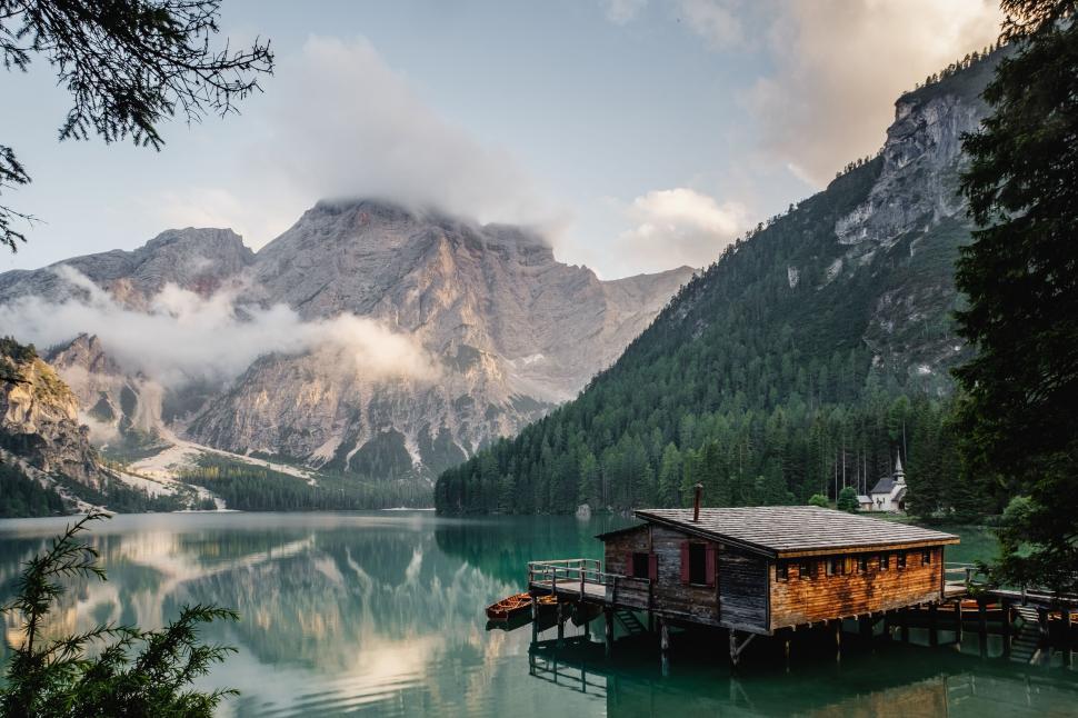 Free Image of Small House on Lake Surrounded by Mountains 