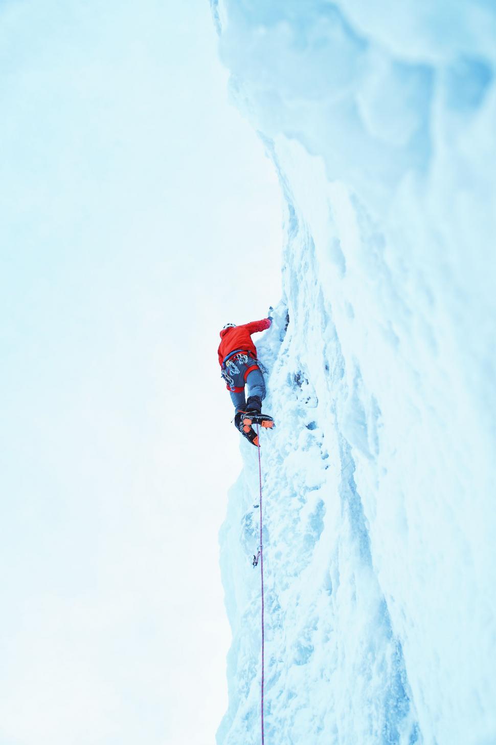 Free Image of Man Climbing Up Snow Covered Mountain 