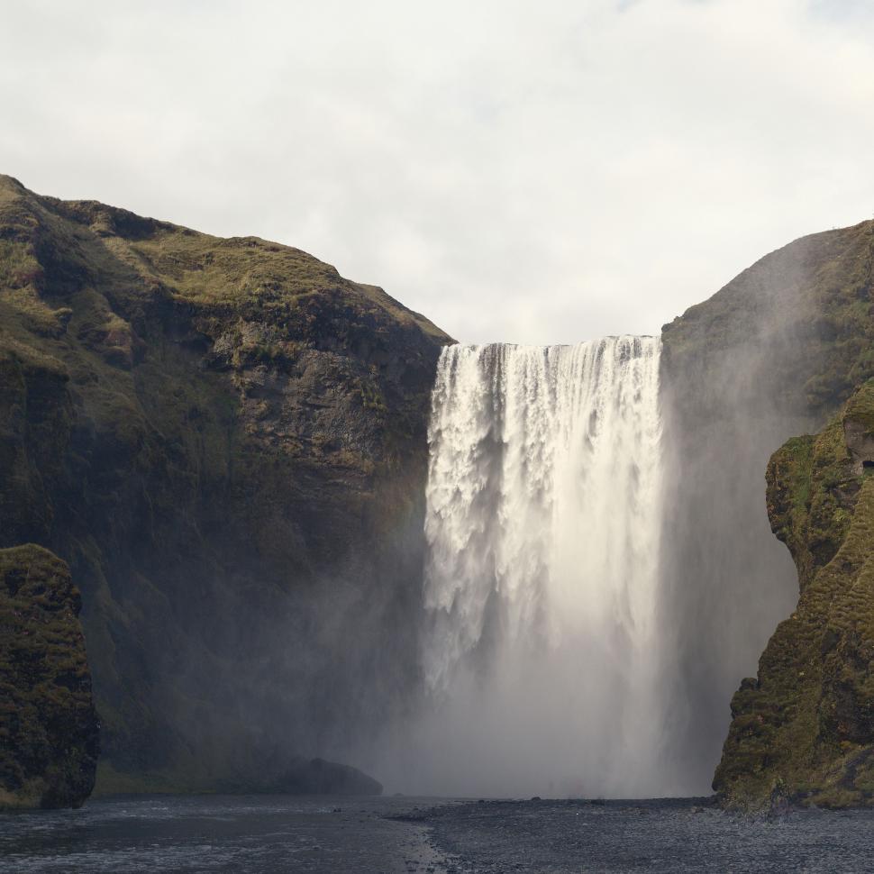 Free Image of Man Standing on Top of Large Waterfall 
