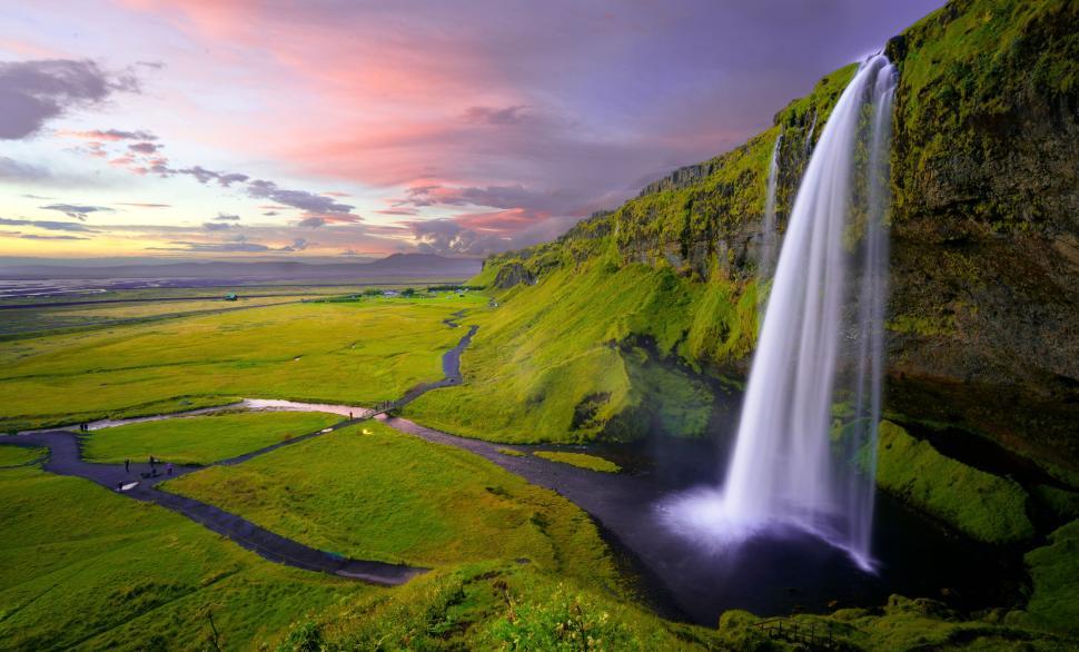 Free Image of Waterfall Cascading Through Lush Green Field 