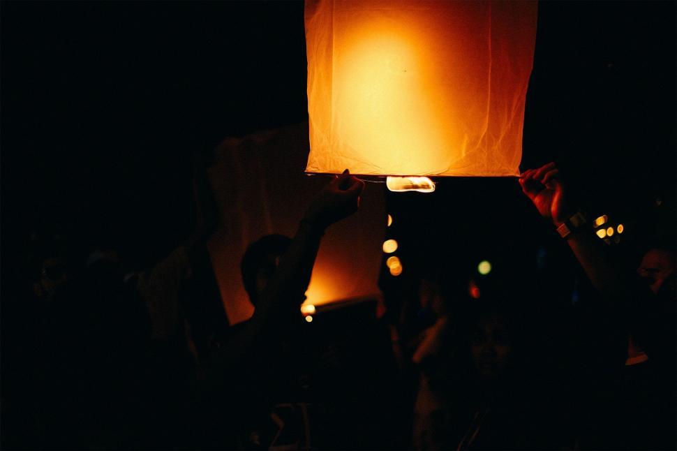 Free Image of Group of People Holding Up a Lit-up Lantern 
