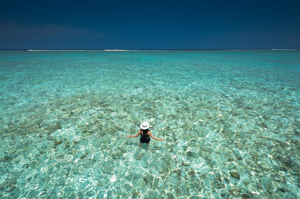Free Image of Person Floating in Ocean With Hat On 