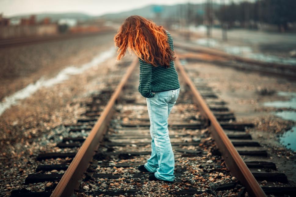 Free Image of Little Girl Standing on Train Track 