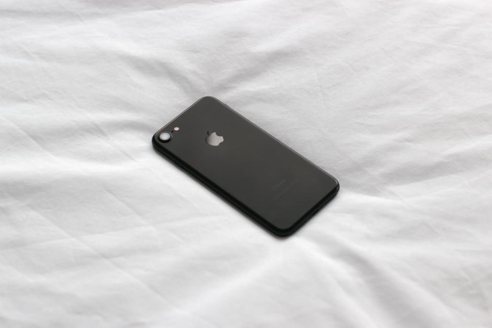 Free Image of Black Iphone Resting on White Sheet 