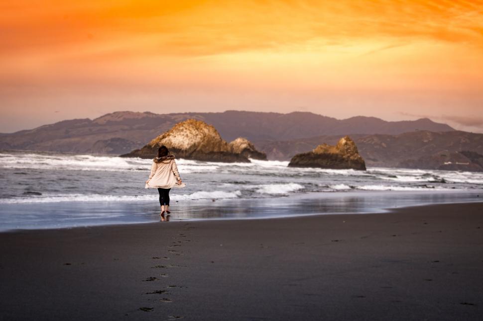 Free Image of Person Walking on Beach Near Ocean 