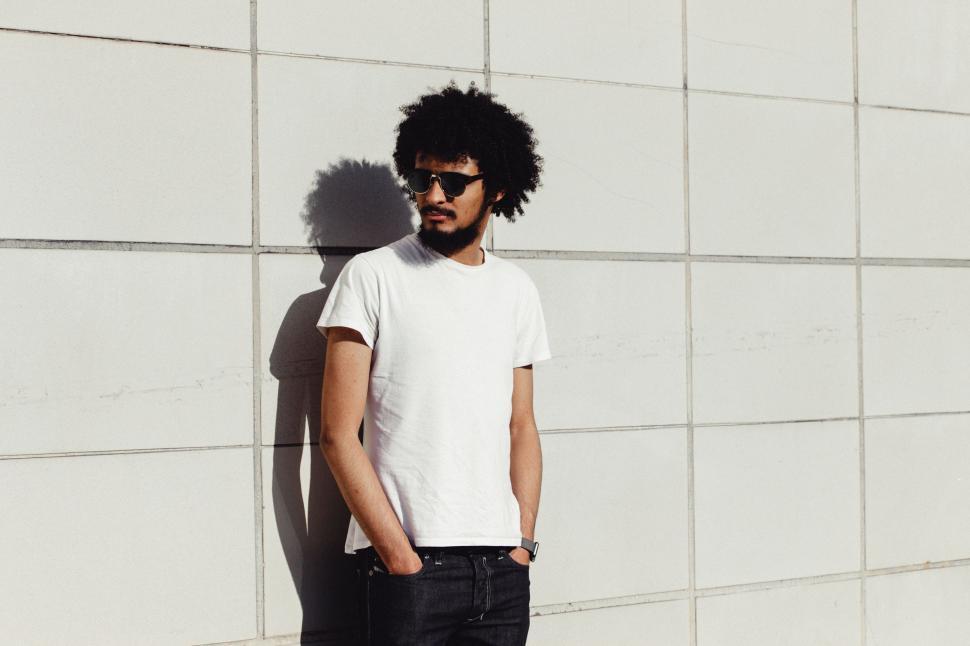 Free Image of Man With Afro Standing in Front of Wall 