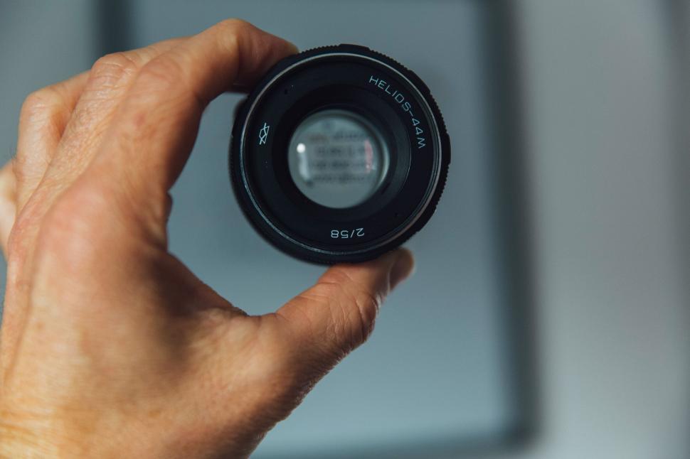 Free Image of Hand Holding Camera Lens in Front of Mirror 