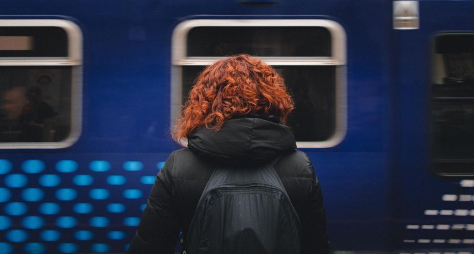 Free Image of Woman With Red Hair Standing in Front of Train 