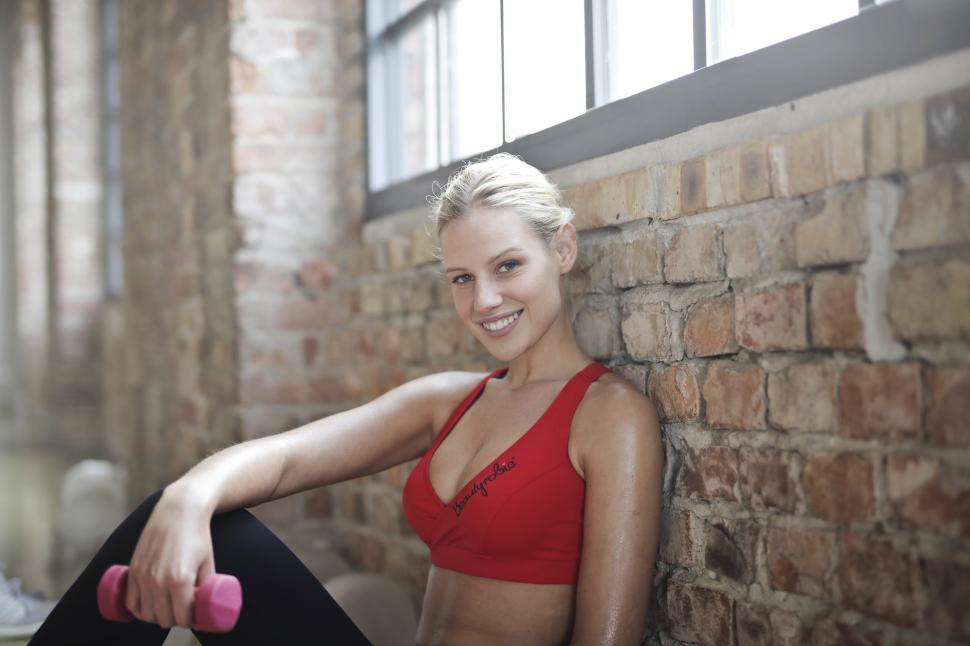 Download Free Stock Photo of Young Woman Wearing Red Sports Bra With Dumbbell In Hand Posing 