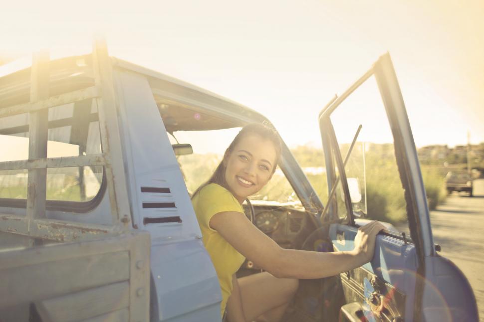 Free Image of Young beautiful woman coming out of pick up truck driving seat 