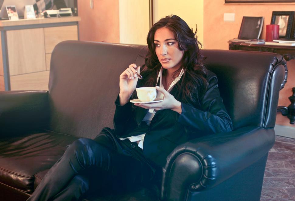 Free Image of Woman in Black Blazer Holding Teacup and spoon 
