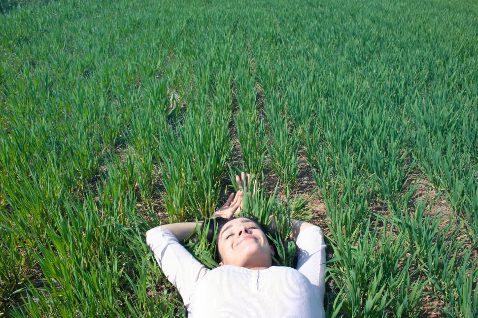 Free Image of Young woman laying on the grass 