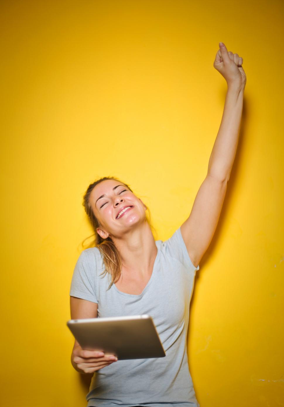 Free Image of Young Happy Woman Holding An iPad 
