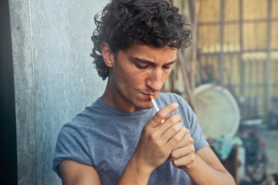 Free Image of Young man lighting up a cigarette 