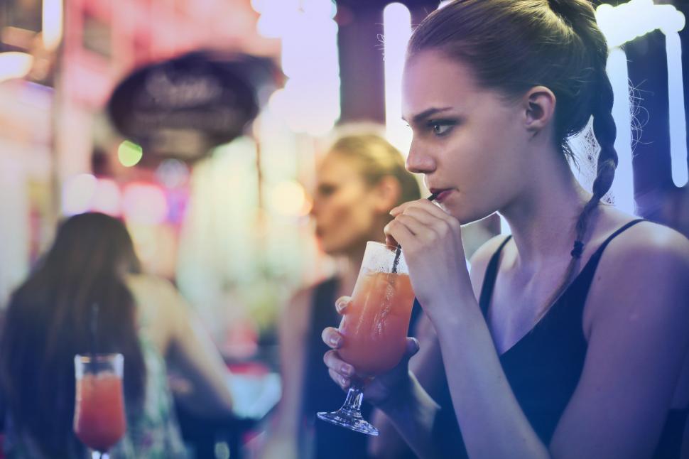 Free Image of Young Woman drinking cocktail with a straw 