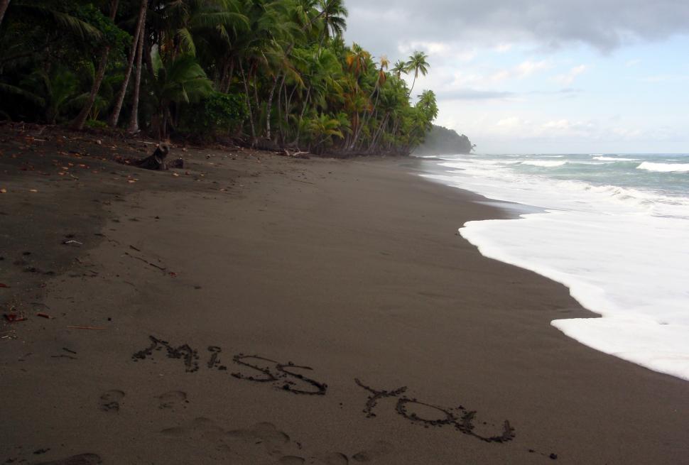 Free Image of  Miss You  written in the sand 