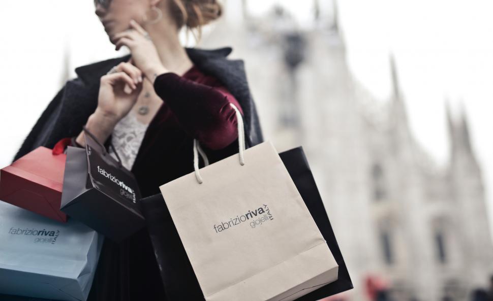 Free Image of A young blond woman holding shopping bags in her hands 