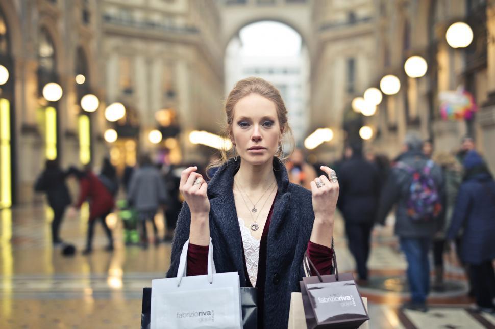 Free Image of A young blonde woman holding shopping bags in her hands 