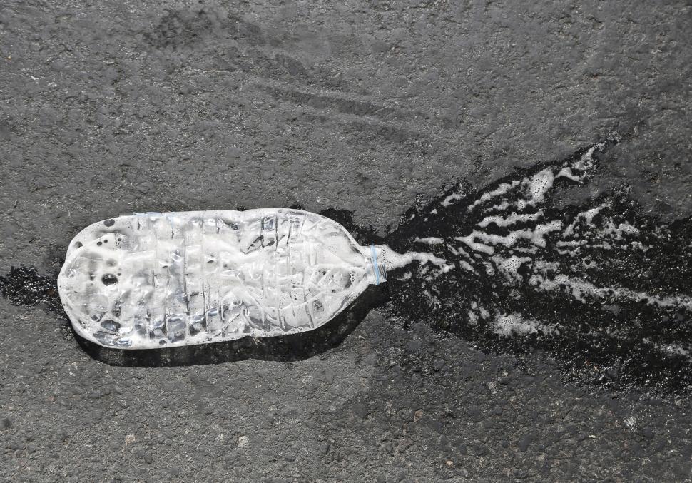 Free Image of A crushed water bottle on the road 