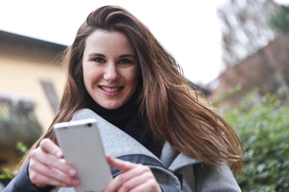 Free Image of A young blonde woman posing with her mobile phone 
