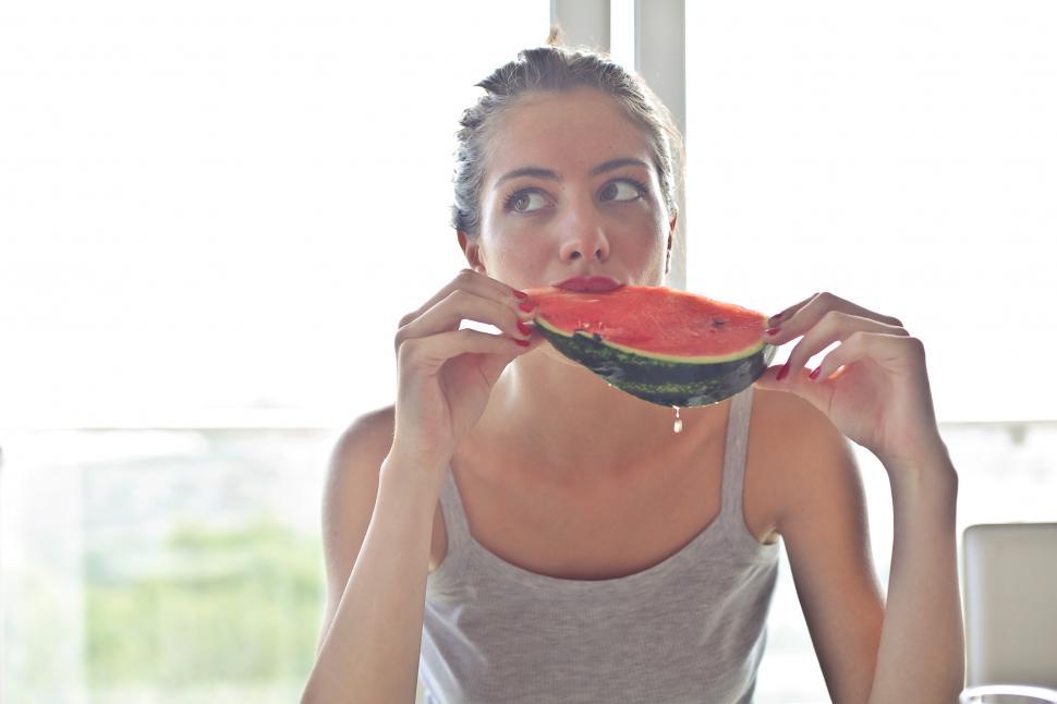 Free Image of Young Woman In Grey Tank Top Eating Watermelon 