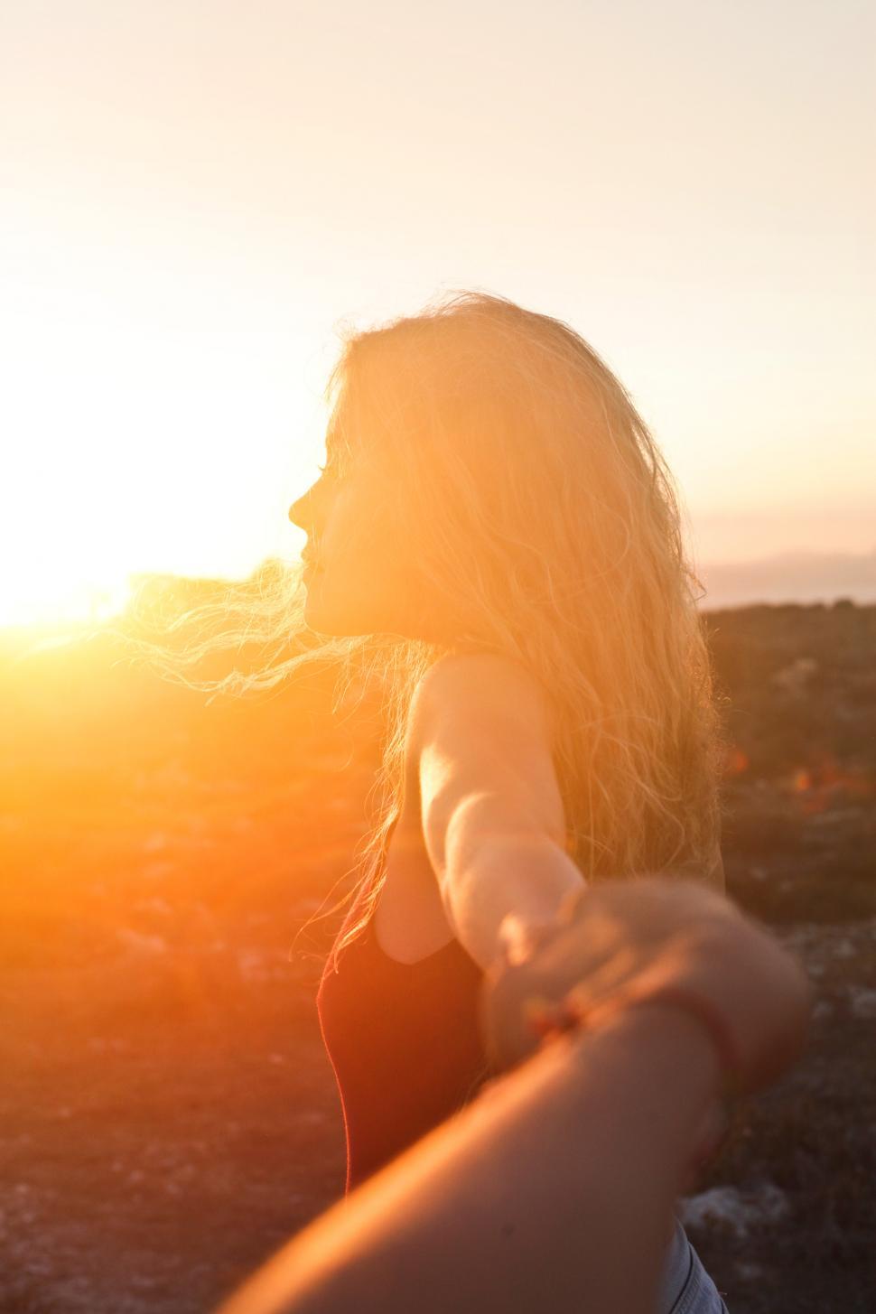 Download Free Stock Photo of A young blonde woman looking at the sunset 