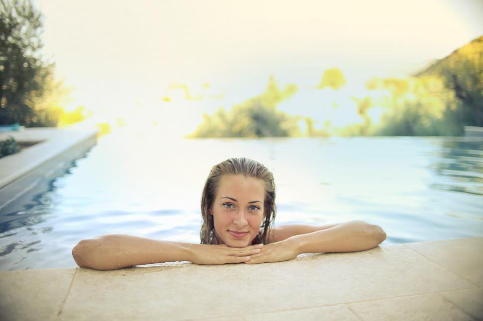 Free Image of A young blonde woman standing the swimming pool with her body in 