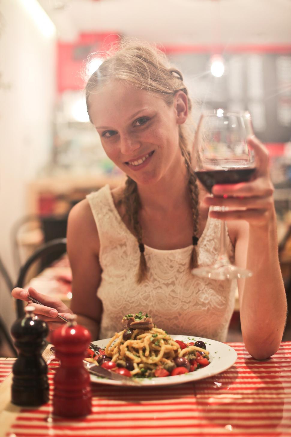 Free Image of Two young blonde women drinking red wine in a restaurant 