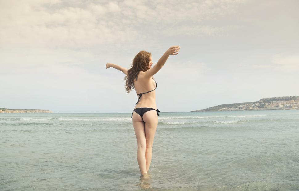 Free Image of A young woman wearing black bikini standing in sea water 