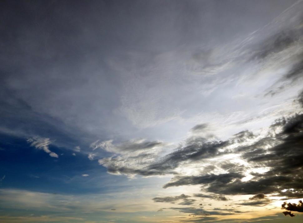 Free Image of Skyscape of sunset sky with sparsly scattered dark clouds  