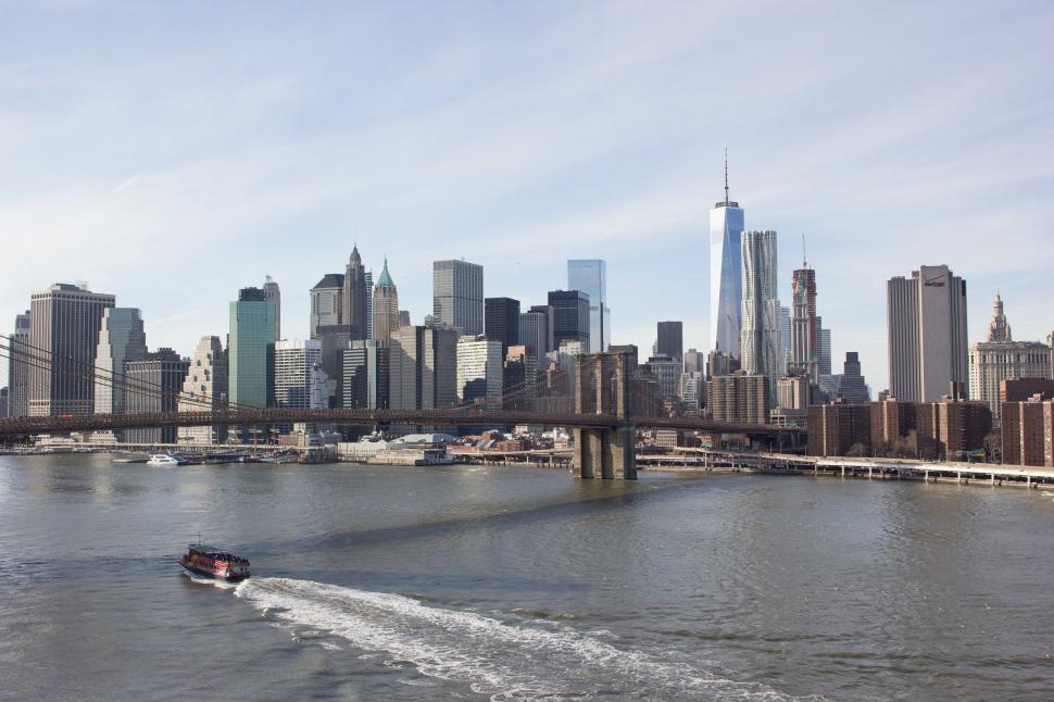 Free Image of A boat passes under Brooklyn bridge 
